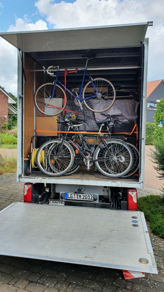 Umzug-LKW gefüllt mit Umzugsgut, wie Fahrräder und Möbel