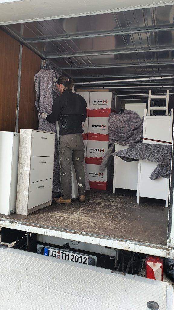 Mitarbeiter von Martens Umzüge sichert Möbel in einem Umzugswagen
