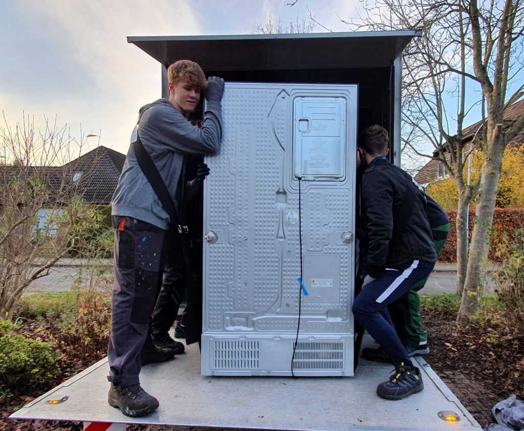 Mitarbeiter von Martens Umzüge verladen einen großen Kühlschrank in einen LKW
